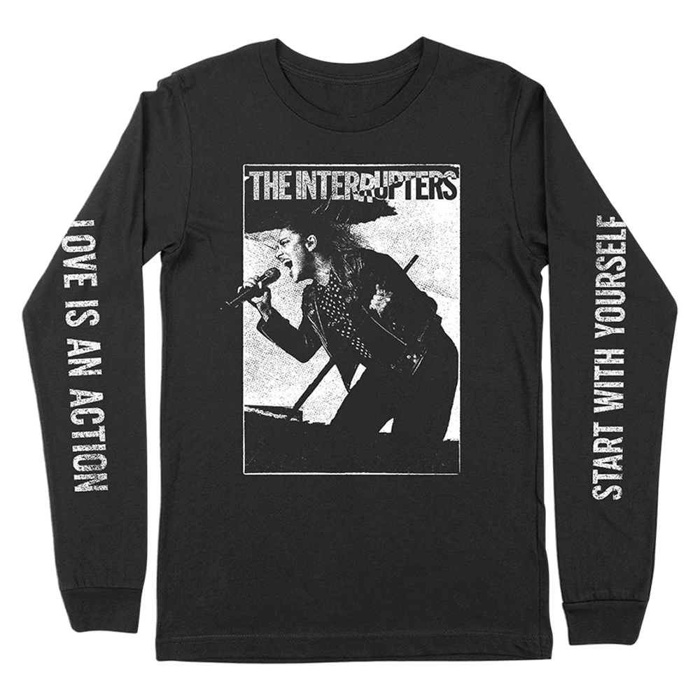 The Interrupters Official Merchandise. 100% black cotton t-shirt with a black and white photo of Aimee Interrupter singing on the front and the lyrics "love is an action, start with yourself" from the song "As We Live" printed down the sleeves.